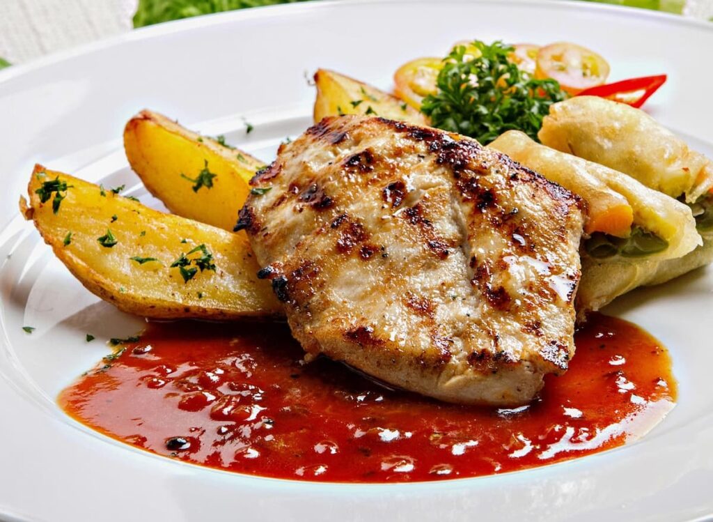 Imagem mostra carne de frango grelhada com batata rústica saborosa.