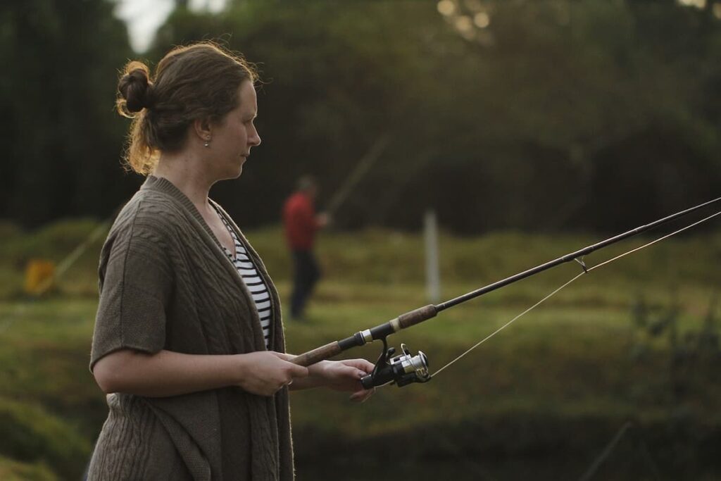 Imagem mostra mulher pescando em hotel fazenda.