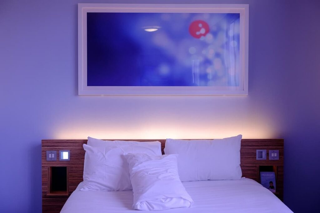 Imagem mostra quarto de hotel simples.