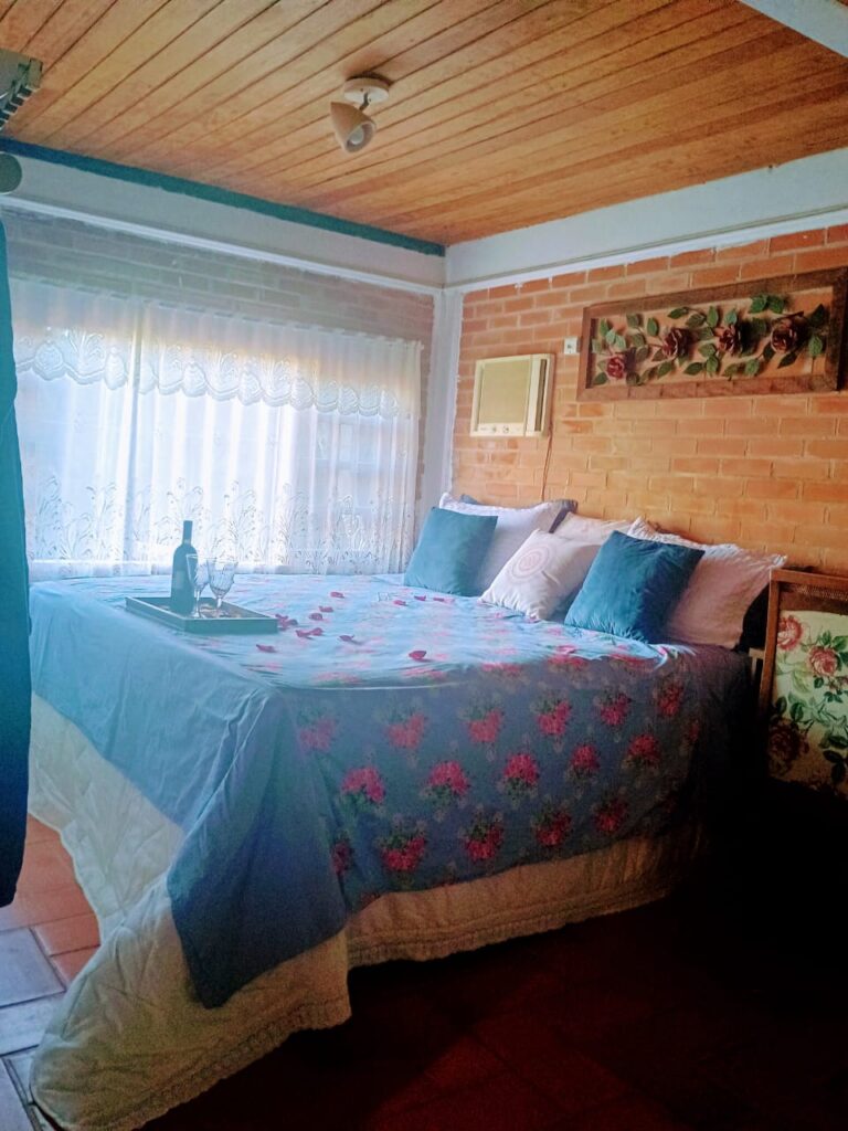 Imagem mostra quarto aconchegante na pousada Lobo da Montanha em Jaguaraçu MG.