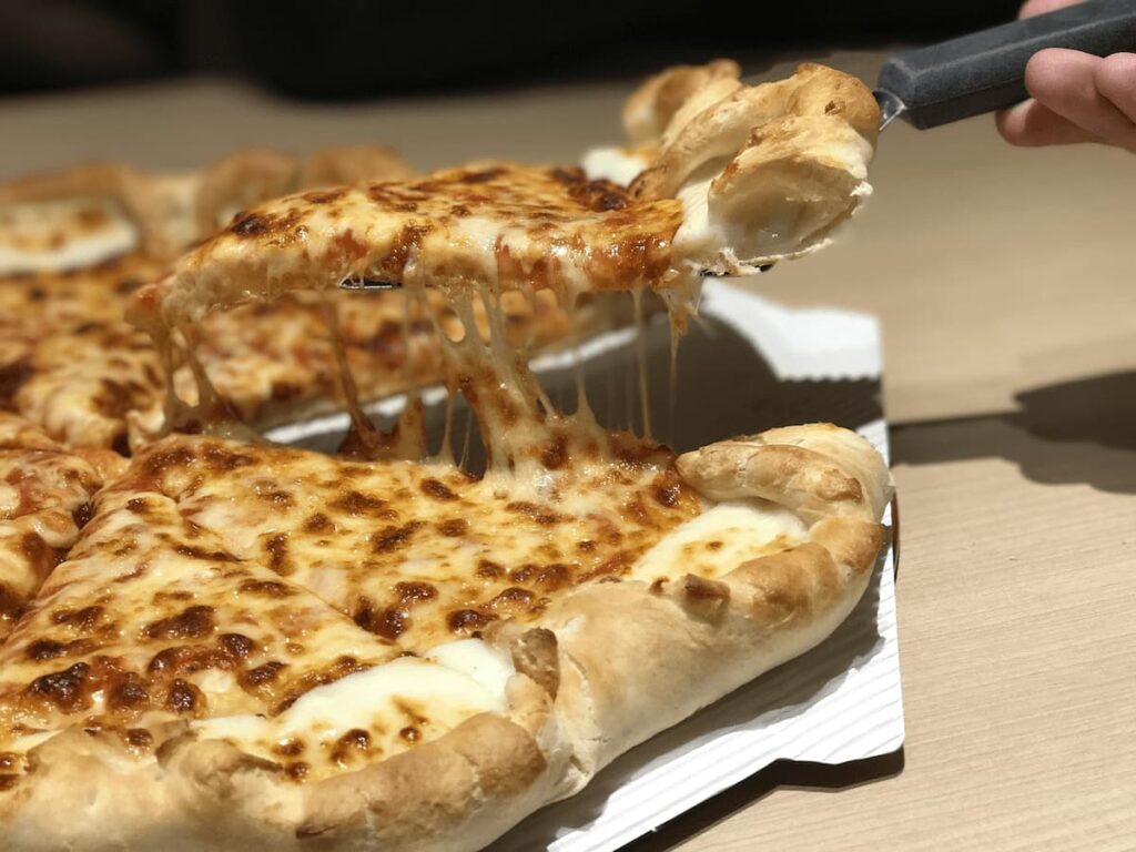 Imagem mostra pizza de queijo com borda servida em uma das melhores pizzarias em Ipatinga.