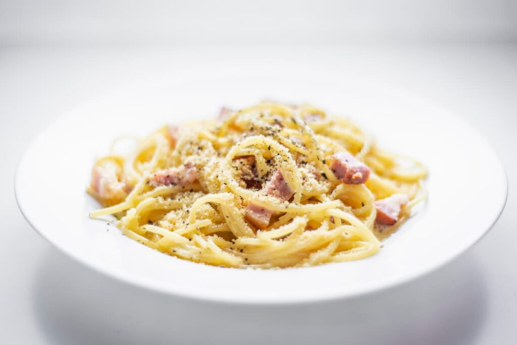 Imagem mostra um belo prato de spaghetti carbonara.