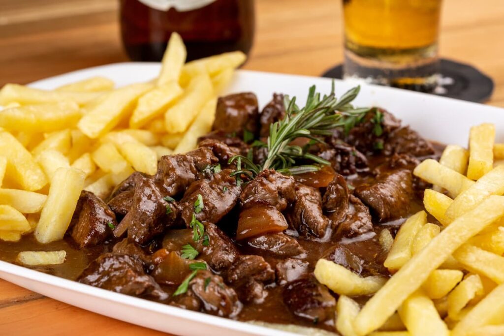 Imagem mostra porção de carne com fritas servida em um dos melhores restaurantes em Timóteo.