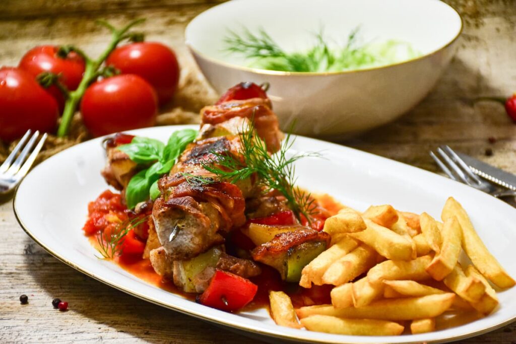 Imagem mostra espetinho de frango com fritas servido em um dos melhores restaurantes em Timóteo.